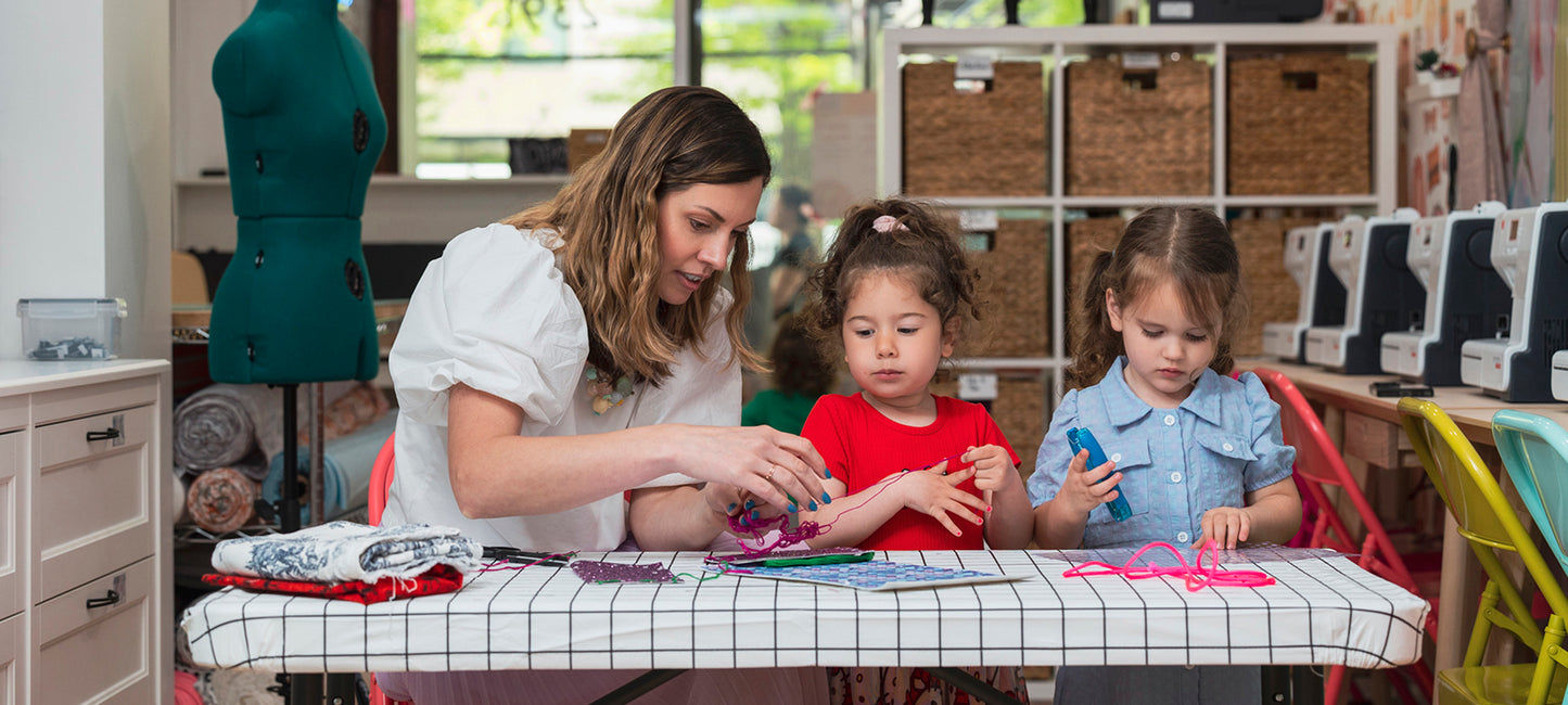 Woman and two children working on a craft project at a table.