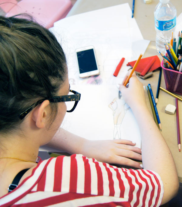 Girl sketching a woman on paper