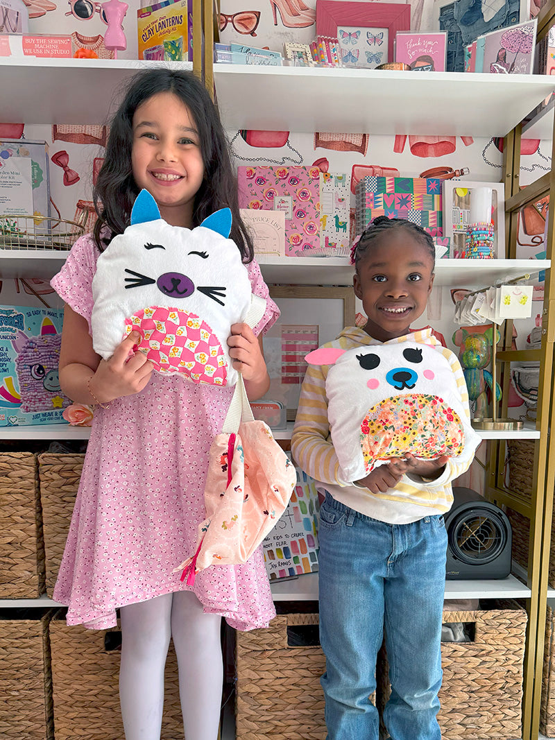 girls holding stuffed animals they sewed