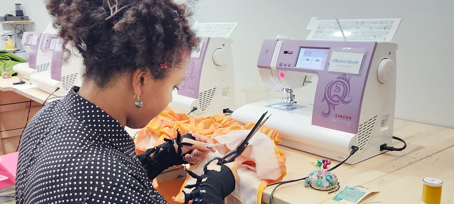 Person working on a sewing project with a sewing machine in a workshop setting