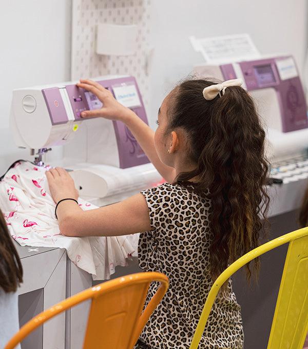 Student learning and operating a sewing machine