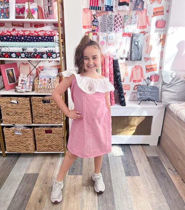 Student posing like a model in sewing summer camp